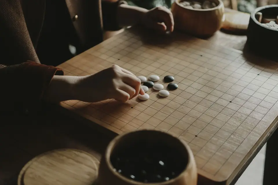 筆電螢幕顯示棋局分析圖表與黑白棋子