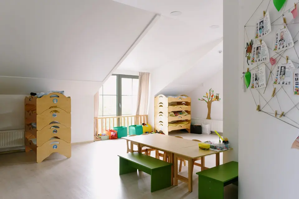 明亮幼兒園教室內的午休床具與收納櫃，呈現設備收納情境