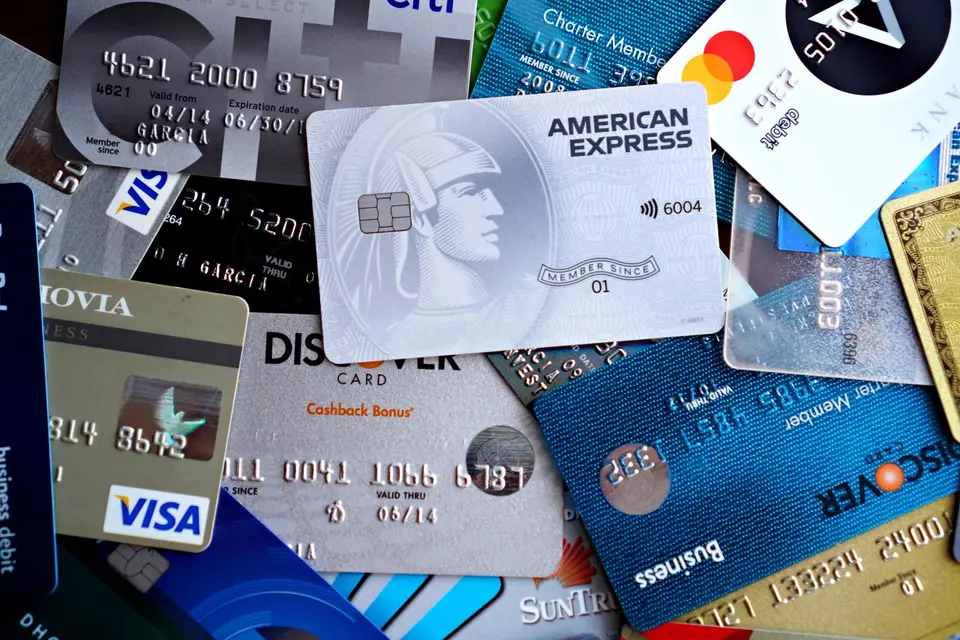 多張信用卡疊放在深色桌面上，象徵兆豐 Apple Pay 綁卡前核對卡別與裝置張數上限（示意圖）
