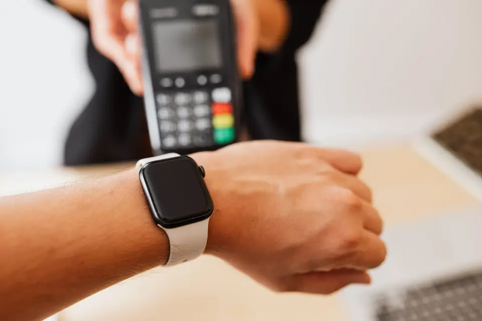 手腕上的智慧手錶顯示行動支付畫面，象徵 Apple Pay 多裝置綁卡與卡片管理（示意圖）