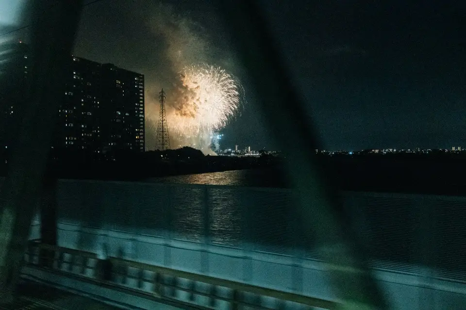 河面上空綻放焰火的節慶夜景