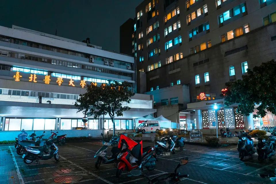 醫院急診入口與明亮的急診標誌，呈現突發頸痛需要緊急處理的場景