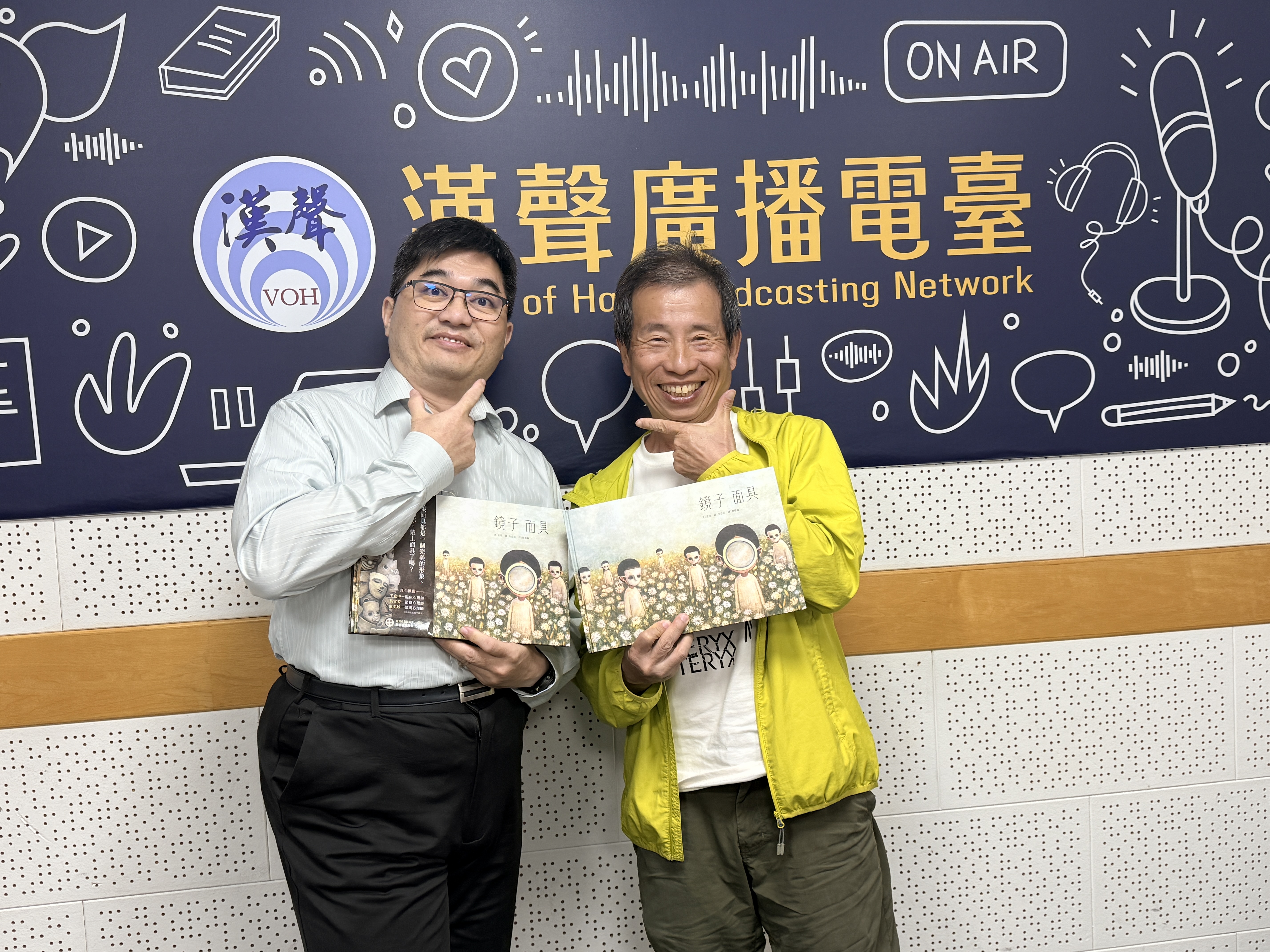錄音室中,林以正老師及Simon展示《鏡子面具》繪本
