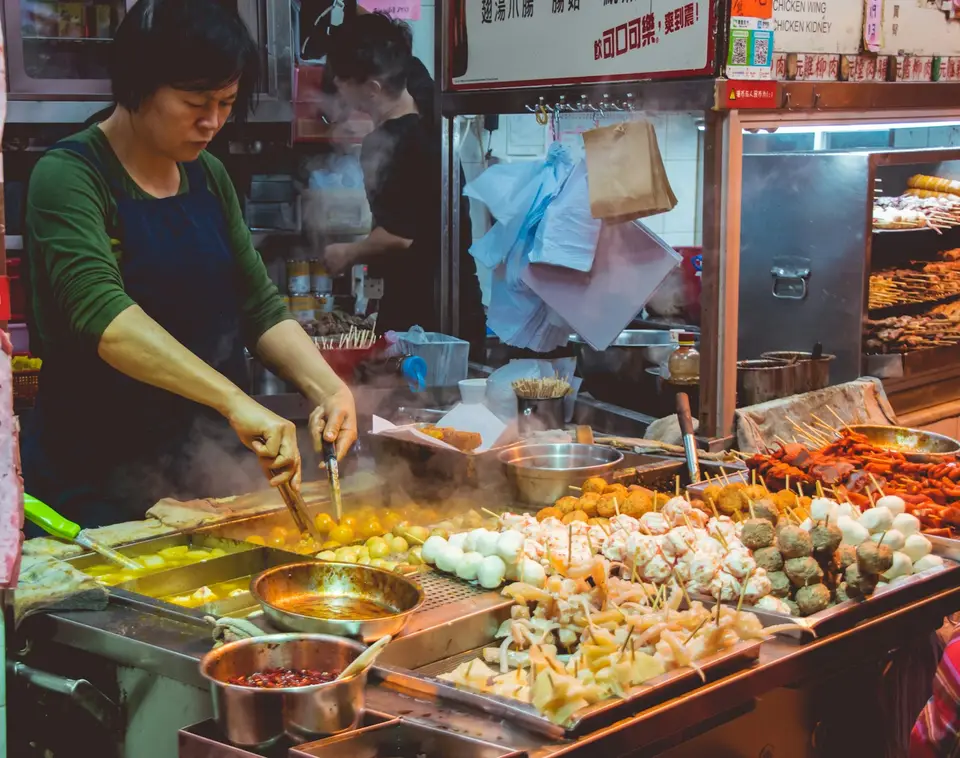 小吃攤販在爐台前熱炒油炸，示意餐飲業者用油成本上升