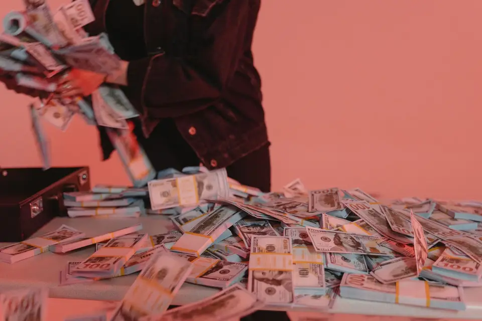 一疊美元現金鈔票放置於桌面