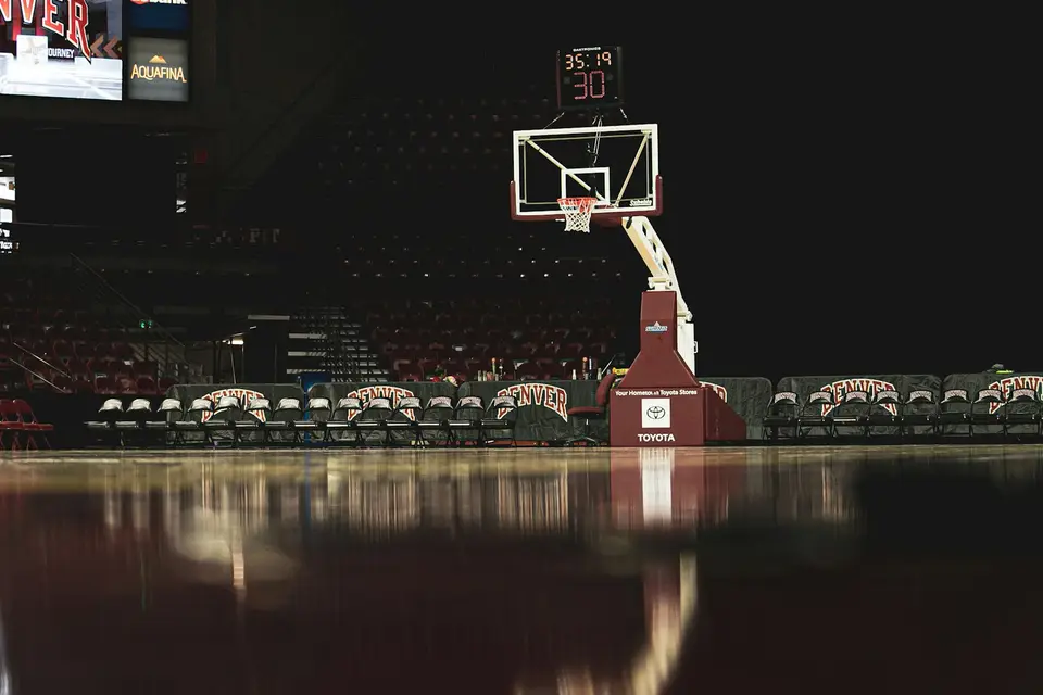 籃球場旁的電視轉播螢幕與球場燈光，呈現觀看 NBA 賽事的場景