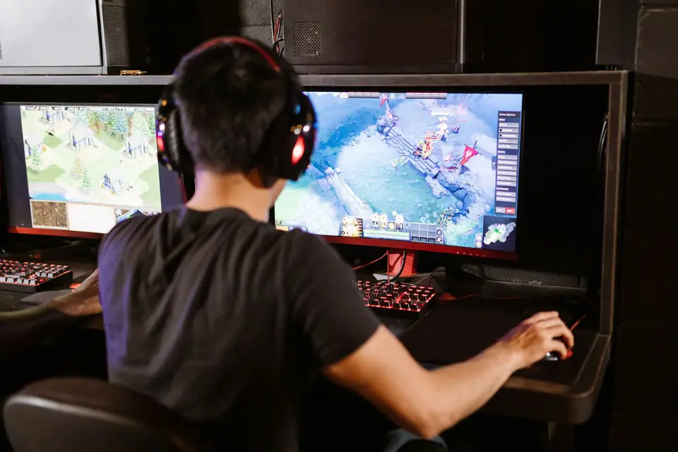 遊戲主機與筆電同時顯示遊戲畫面，呈現家庭成員各自使用遊戲裝置的情境