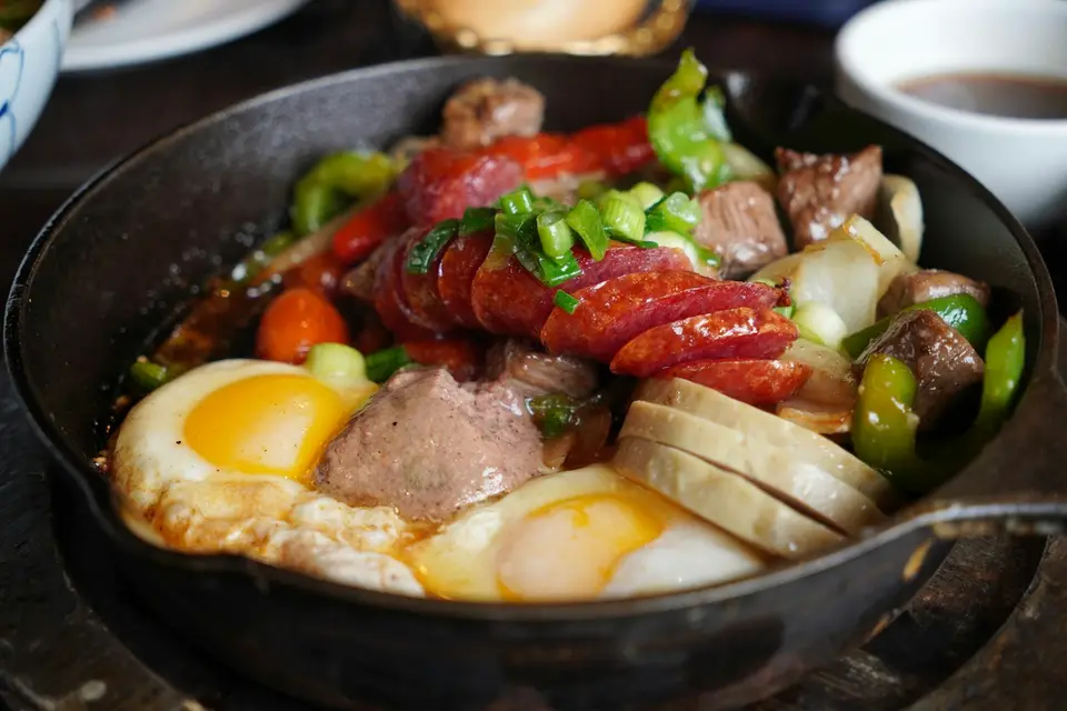 鑄鐵鍋中烹煮牛肉與蔬菜的壽喜燒料理畫面