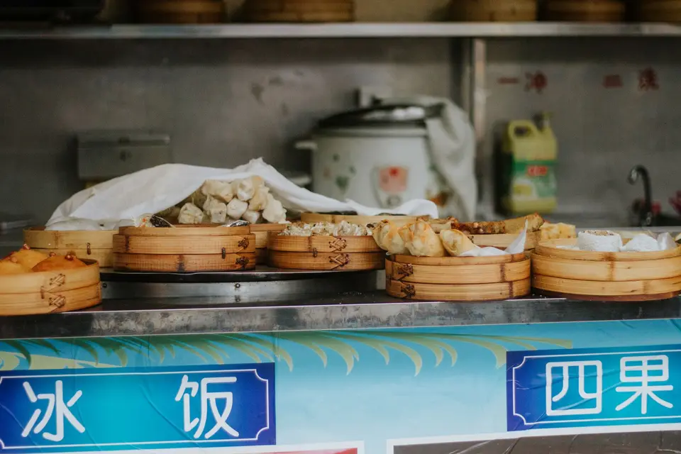 竹蒸籠內擺放多顆剛蒸好的包子與饅頭，呈現中式早餐店的蒸點品項