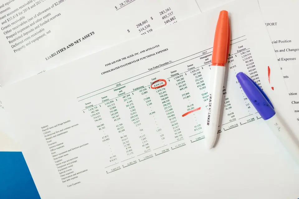 桌面上的資產配置檢查表、投資紀錄、計算機與筆記工具