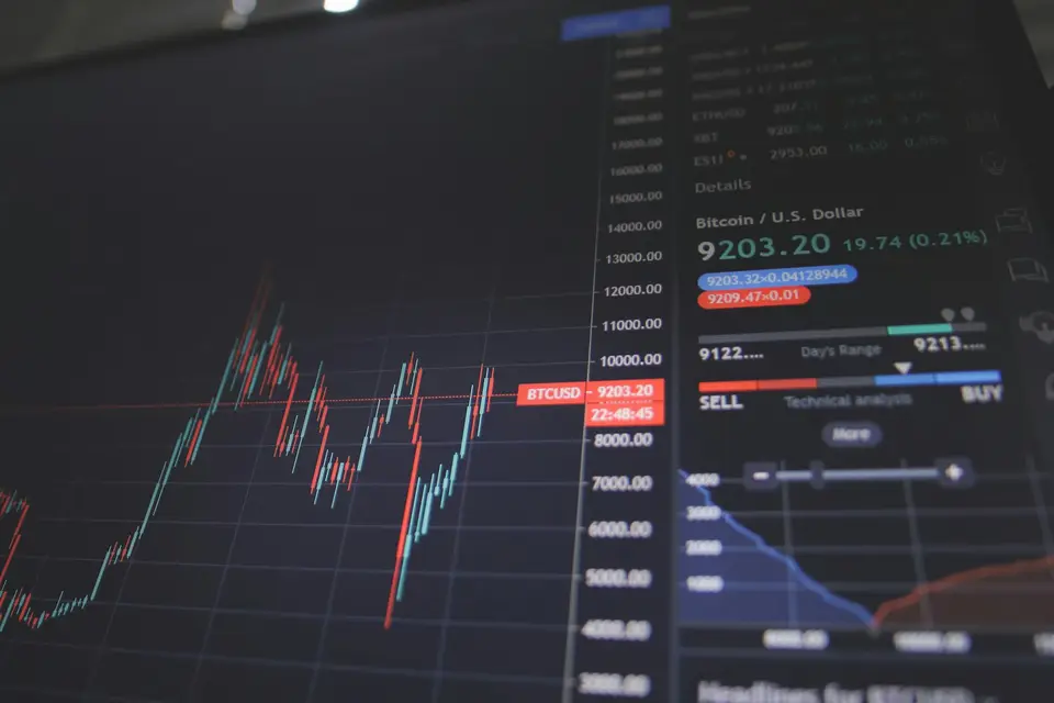 手機與螢幕顯示股票價格走勢，象徵投資人即時查看盤後行情