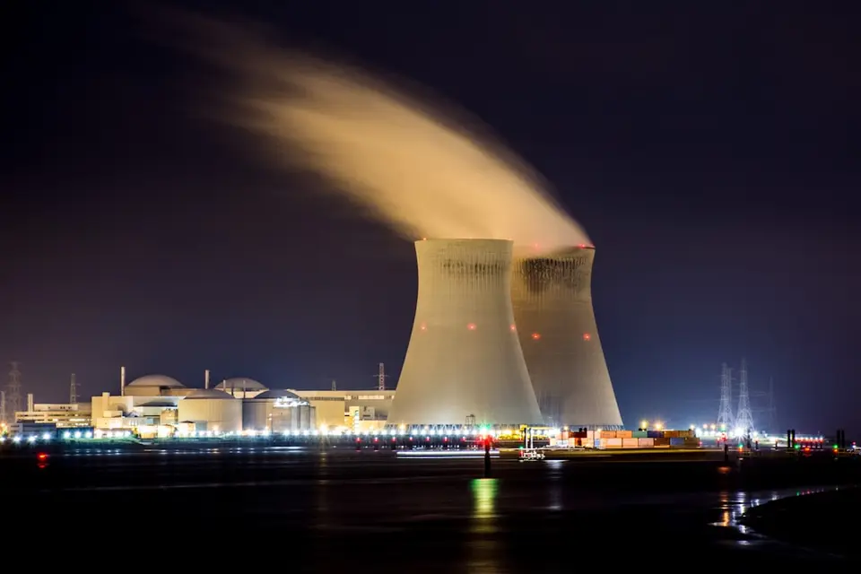 電廠冷卻塔與排放，象徵碳費涵蓋的電力與製造業排放源