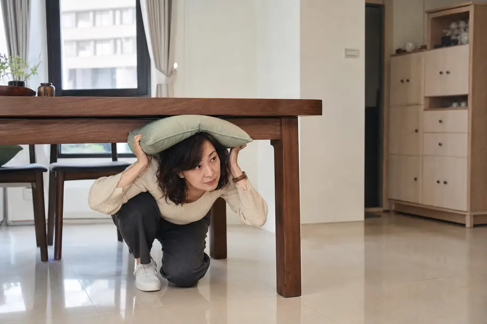 台灣住家客廳的堅固桌子與保護頭頸的墊子，窗戶與高櫃位在遠處。