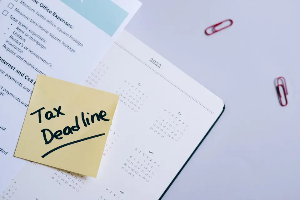 企業計畫書、申請須知、日曆與文件夾放在辦公桌上，象徵逐案核對條件與期限