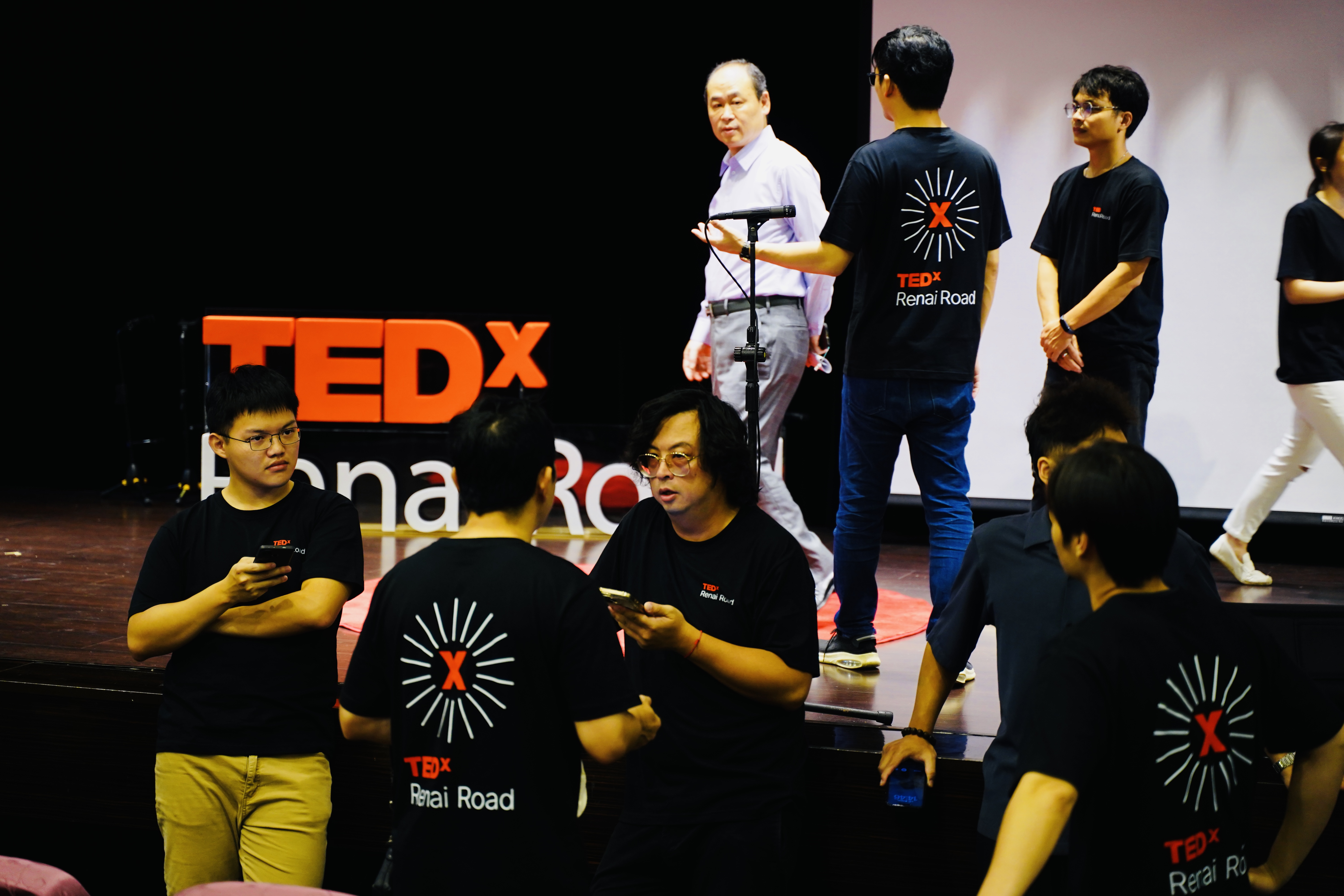 TEDxRenaiRoad舞台上的工作人員與志工正在執行現場流程，呈現舞台管理與幕後協作