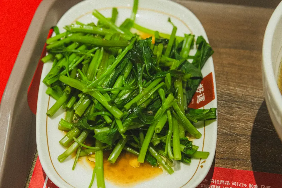 翠綠的水蓮在熱鍋中翻炒，油光發亮