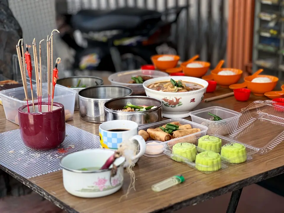 住宅一隅的小供桌擺放米飯、五味碗、蘿蔔糕與香爐，呈現拜地基主供品