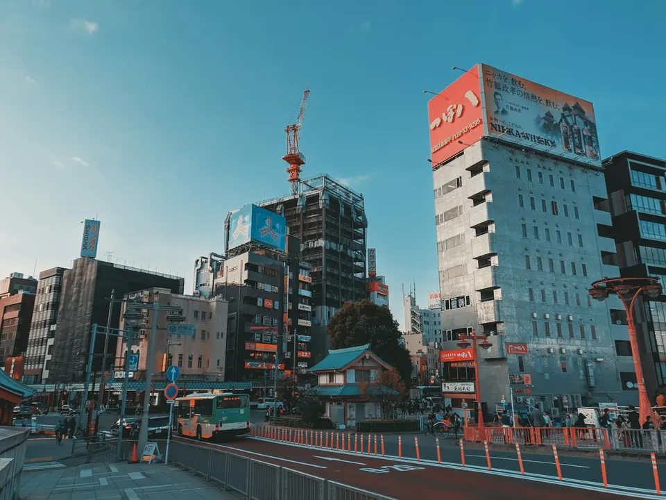 東京街頭，日式招牌與高樓林立，晴天下的都市風景顯示出東京的現代商業氛圍