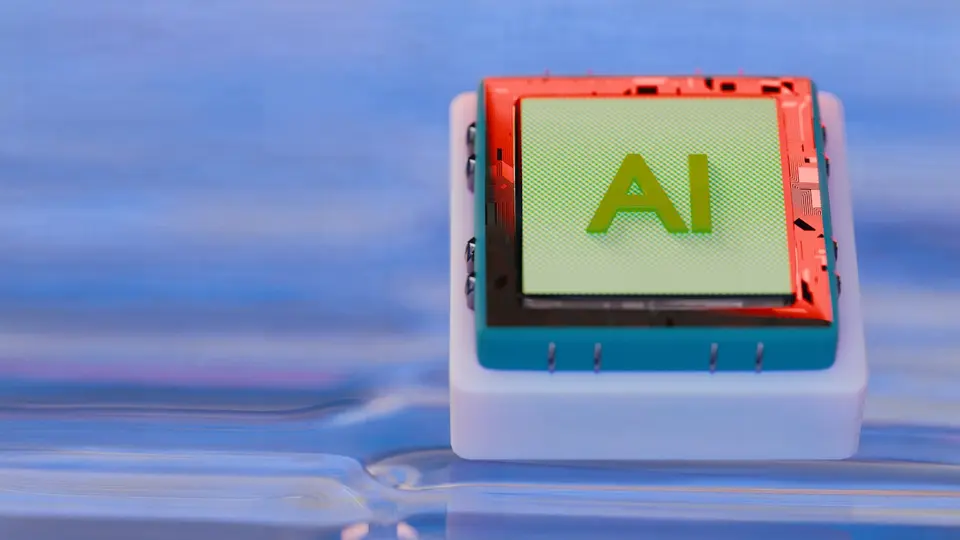 標示著「AI」字樣的彩色晶片模型，紅色外框搭配綠色面板，置於藍色電路板上