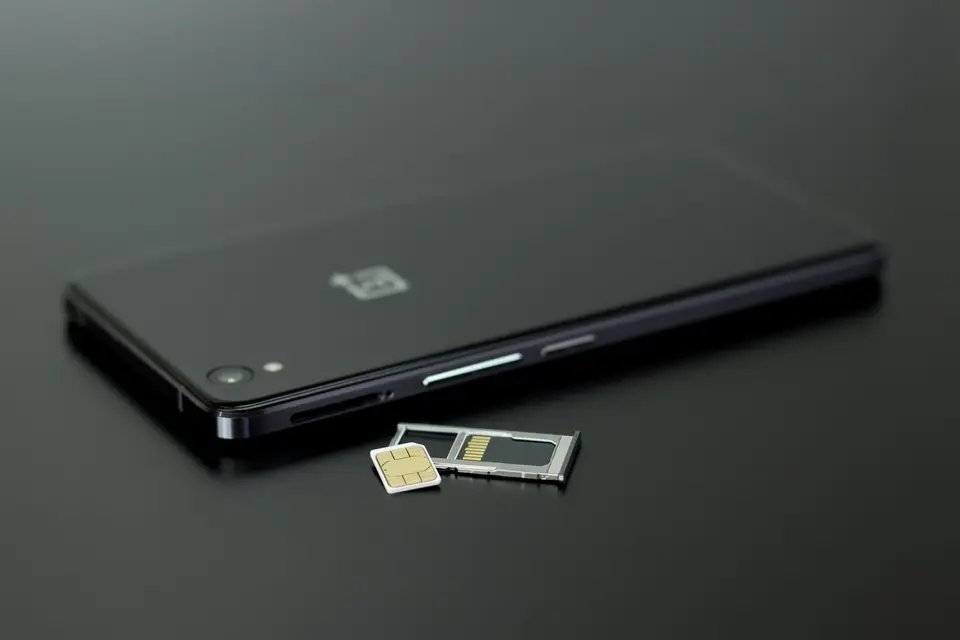 一支智慧型手機與記憶卡、SIM 卡托盤放在桌面上，呈現儲存空間擴充情境